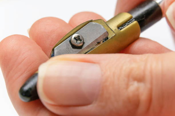 Close-up of eyeliner pencil being sharpened with a blade

