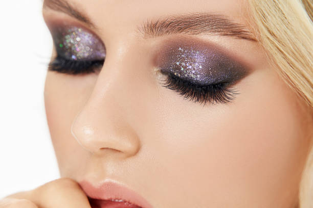 Close-up of a woman's eyes with glittery, dramatic evening makeup look, showcasing bold and shimmering eye shadow.